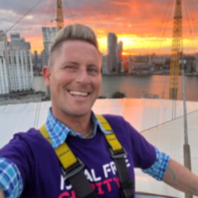 Man smiling with a sunset in the background
