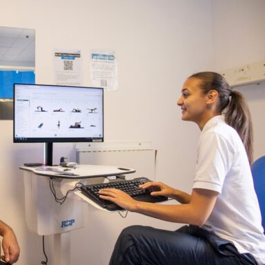 A female physiotherapist viewing some excercise plans on a computer.