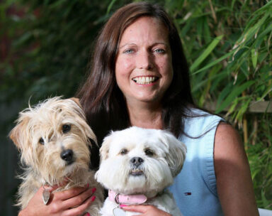 Nicola Whitehill, volunteer ambassador holding her two dogs.