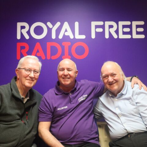 Three men sat in front of a purple wall that says 'Royal Free Radio'