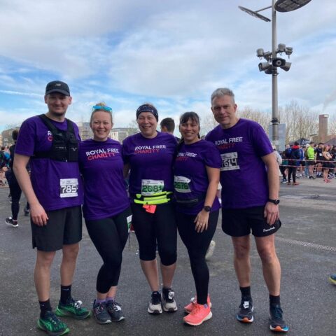Five people standing in a row at a running event, all wearing Royal Free Charity t-shirts.
