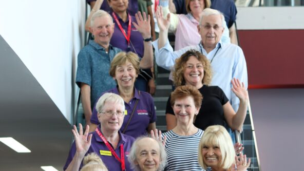 A group photos of lots of volunteers stood on a staircase.