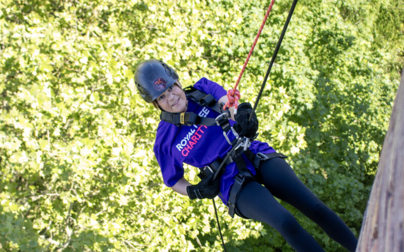 A woman abseiling in Royal Free Charity branded colours.