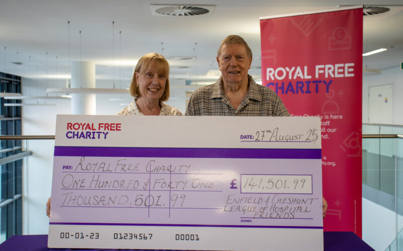 A woman and man stood behind a big cheque for £141,501.99.