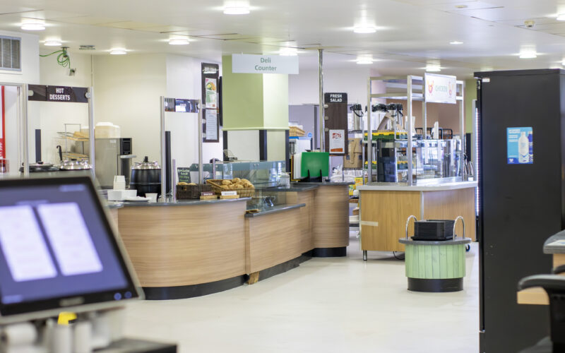 A hospital restaurant counter with a till in the foreground.