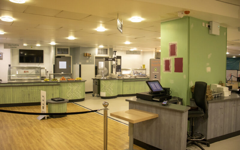 A hospital restaurant before refurbishment, with green counters and walls.