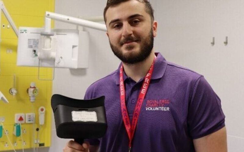 A man smiling at the camera while holding a VR headset.