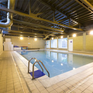 Indoor shot of an empty swimming pool with tiled flooring around it