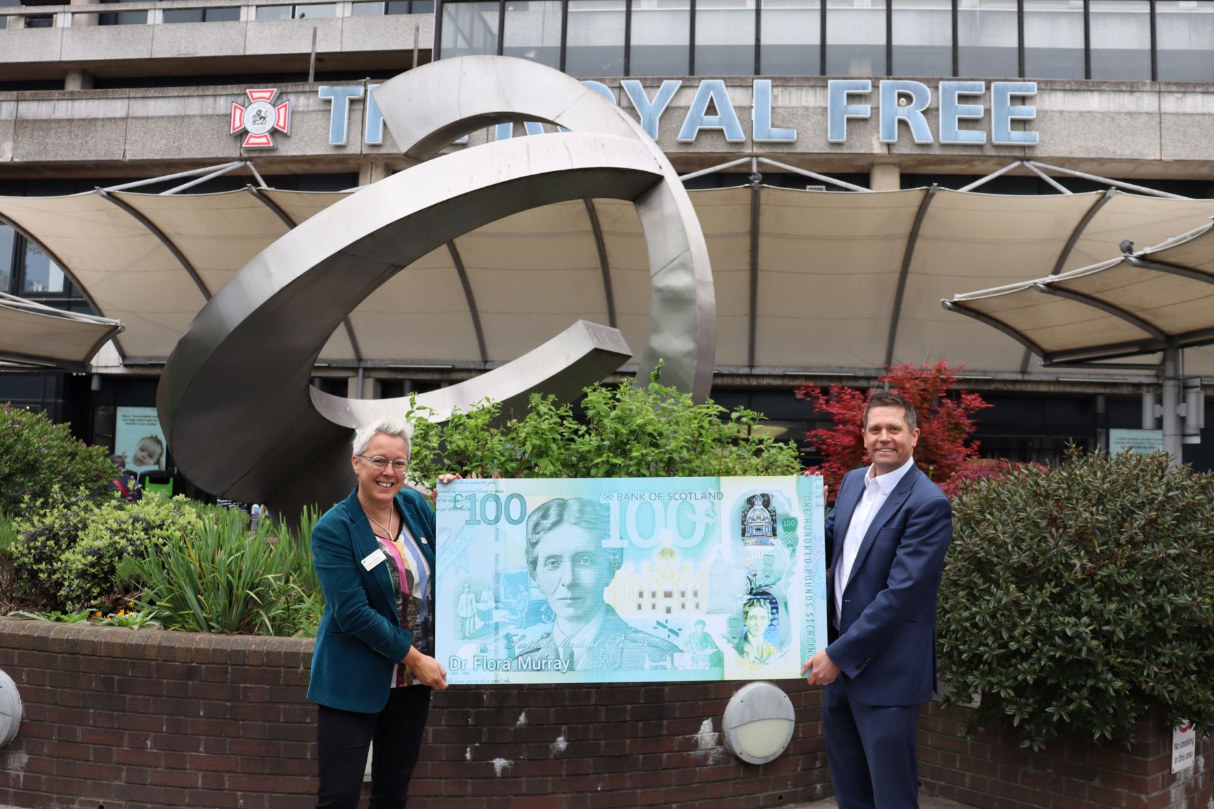 Caroline Clarke, chief executive of the Royal Free London NHS Foundation Trust and Jon Spiers, chief executive of the Royal Free Charity, pictured with a large replica banknote featuring Dr Flora Murray