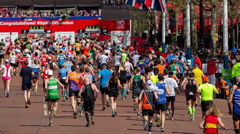 Outdoor shot of hundreds of runners in a race down The Mall in London