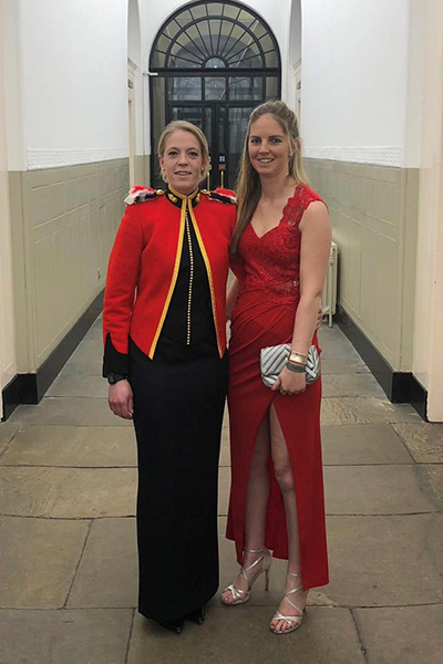 Two women in formal attire stood together in a hallway.