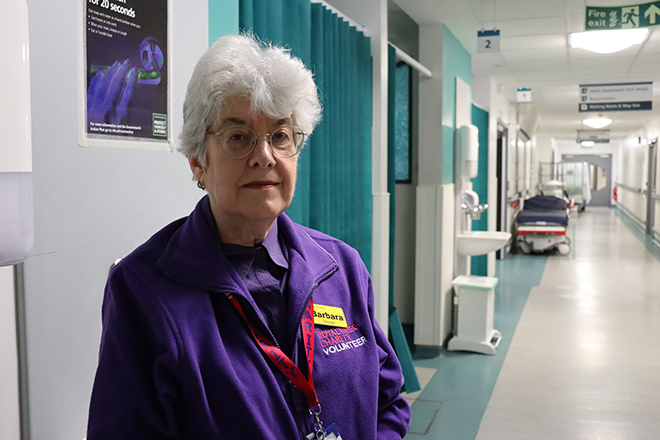 Women in Royal Free Charity volunteer fleece stood in a corridor of a hospital emergency department